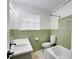 Well-lit bathroom with a shower-tub combo, single sink vanity, and green tile accents at 1083 Amelia Sw Dr, Marietta, GA 30060