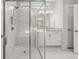 Modern bathroom features a glass enclosed shower, marble tile, and white cabinets at 1629 Tielman Way, Snellville, GA 30078