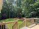 A wooden deck overlooks a lush, green backyard surrounded by mature trees at 328 West Ln, Woodstock, GA 30188