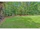 Expansive backyard with verdant green grass and mature trees, perfect for outdoor activities at 328 West Ln, Woodstock, GA 30188