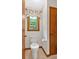 Powder room featuring a standard toilet, natural lighting, and a decorative shade at 328 West Ln, Woodstock, GA 30188
