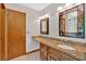 Bright bathroom features granite countertop, decorative mirrors, and wooden door at 328 West Ln, Woodstock, GA 30188