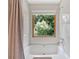 Bright white bathroom with a tub and an outdoor view at 328 West Ln, Woodstock, GA 30188