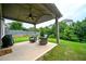 Covered back patio featuring two comfortable chairs, a ceiling fan and outdoor grill overlooking the yard at 3291 Meadow Lily Ct, Buford, GA 30519