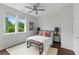 Bright bedroom featuring hardwood floors, ceiling fan, two windows with neighborhood views and bench at the end of the bed at 415 Gartrell Se St # 15, Atlanta, GA 30312