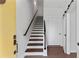 Bright entryway featuring hardwood floors, a wooden staircase, and contemporary white doors with black hardware at 415 Gartrell Se St # 15, Atlanta, GA 30312