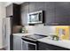 Close-up of a kitchen area with stainless steel appliances, white countertops, and dark wood cabinets at 415 Gartrell Se St # 15, Atlanta, GA 30312