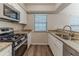 Modern kitchen featuring stainless steel appliances, granite countertops, and white cabinets at 482 Tarragon Sw Way, Atlanta, GA 30331