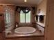 Elegant bathroom featuring a luxurious soaking tub and decorative glass block accents at 716 Bethpage Dr, Mcdonough, GA 30253