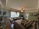 Bright bedroom features a large window with comfortable seating, a ceiling fan, and plenty of pillows on the bed at 716 Bethpage Dr, Mcdonough, GA 30253
