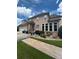 Side view of a home featuring a three-car garage, manicured lawn, and stamped concrete pathway at 716 Bethpage Dr, Mcdonough, GA 30253