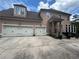 Large three-car garage with ample parking space and a well-maintained driveway at 716 Bethpage Dr, Mcdonough, GA 30253