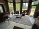 Bright sunroom with tiled flooring, a glass top coffee table, comfortable seating, and many windows at 716 Bethpage Dr, Mcdonough, GA 30253