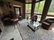 Inviting sunroom with tiled flooring, an area rug, glass top coffee table, and comfortable seating at 716 Bethpage Dr, Mcdonough, GA 30253