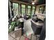 Bright sunroom featuring multiple windows, wicker furniture, potted plants, and a ceiling fan at 716 Bethpage Dr, Mcdonough, GA 30253