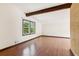 Bright living room with wood floors, beam ceiling, and large window overlooking mature trees at 3623 Doroco Dr, Atlanta, GA 30340