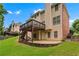 The house's rear exterior features a deck, stairs, gravel foundation, and lush green lawn at 871 Windsor Creek Dr, Grayson, GA 30017