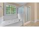Bright bathroom features a jacuzzi tub, separate shower, and decorative window at 871 Windsor Creek Dr, Grayson, GA 30017