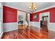 Formal dining room with red walls, hardwood floors, and elegant chandelier at 871 Windsor Creek Dr, Grayson, GA 30017