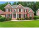 Elegant brick home with a manicured lawn and lush landscaping at 871 Windsor Creek Dr, Grayson, GA 30017