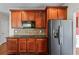 The cozy kitchen is equipped with stainless steel refrigerator, granite counters and wood cabinets at 871 Windsor Creek Dr, Grayson, GA 30017
