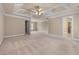 Large primary bedroom with tray ceiling, plush carpeting and doors that lead to the walk-in closet at 871 Windsor Creek Dr, Grayson, GA 30017