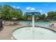 Community pool with splash pad, shade umbrellas, lounge chairs and lush landscape at 871 Windsor Creek Dr, Grayson, GA 30017