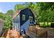 Side exterior of blue house with a wooden deck and fenced yard surrounded by trees at 1454 Rome Nw Dr, Atlanta, GA 30314