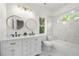 Elegant bathroom with double vanity, marble countertops, tub and white cabinetry at 1454 Rome Nw Dr, Atlanta, GA 30314