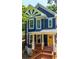 Charming two-story home featuring blue siding, white trim, and a welcoming yellow front door at 1454 Rome Nw Dr, Atlanta, GA 30314