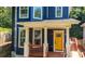 Inviting blue home with a bright yellow door, showcasing classic architectural details and a cozy front porch at 1454 Rome Nw Dr, Atlanta, GA 30314