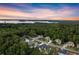 Stunning sunset view of lakefront homes surrounded by lush trees in a serene community at 6750 Pannell Rd, Buford, GA 30518