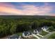Stunning aerial view of modern homes nestled among lush trees, picturesque landscape, and beautiful sunset at 6750 Pannell Rd, Buford, GA 30518
