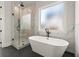 Elegant bathroom showcasing a freestanding tub, glass shower, and marble-like tiling at 6750 Pannell Rd, Buford, GA 30518