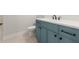 A bathroom features a stone countertop, blue vanity, and toilet with tile floors at 6750 Pannell Rd, Buford, GA 30518