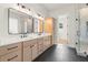 Bright bathroom featuring double vanity with black hardware, walk-in shower, and linen cabinet at 6750 Pannell Rd, Buford, GA 30518