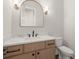 Powder room featuring a wood vanity, a gold trimmed mirror, and matte black fixtures at 6750 Pannell Rd, Buford, GA 30518