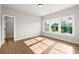 A bright room features hardwood floors and multiple large bright windows at 6750 Pannell Rd, Buford, GA 30518
