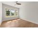 Sunlit bedroom with hardwood floors, ceiling fan, and expansive windows overlooking the landscape at 6750 Pannell Rd, Buford, GA 30518