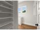 Walk-in closet with custom shelving and drawers, bathed in natural light from the window at 6750 Pannell Rd, Buford, GA 30518