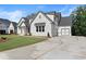 Lovely new construction home featuring white painted brick, black trim, and an attached two-car garage at 6750 Pannell Rd, Buford, GA 30518