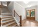 Elegant foyer featuring herringbone floors, wood and iron staircase with beautiful wooden french doors at 6750 Pannell Rd, Buford, GA 30518