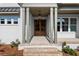 Stunning new home features a beautiful brick porch with wood door and white brick exterior at 6750 Pannell Rd, Buford, GA 30518