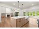 Kitchen with center island and stainless appliances open to living room and breakfast nook at 6750 Pannell Rd, Buford, GA 30518