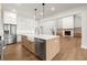 Kitchen shows stainless appliances and sink with large island, open to living room with fireplace at 6750 Pannell Rd, Buford, GA 30518