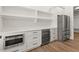 Stylish kitchenette features white cabinetry, stainless steel appliances, and open shelving at 6750 Pannell Rd, Buford, GA 30518