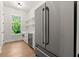 View of the bright kitchenette, featuring a stainless steel refrigerator and light wood floors at 6750 Pannell Rd, Buford, GA 30518