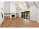 Spacious living room featuring wood floors, fireplace, high ceilings, and access to a screened-in porch at 6750 Pannell Rd, Buford, GA 30518