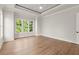 Bright main bedroom with tray ceilings, hardwood floors, and a ceiling fan at 6750 Pannell Rd, Buford, GA 30518