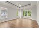 Spacious main bedroom with tray ceiling, fan, and multiple windows providing natural light at 6750 Pannell Rd, Buford, GA 30518